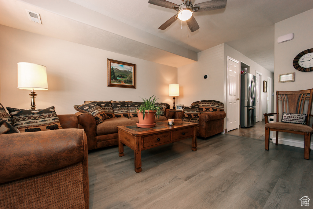 Living room featuring ceiling fan and dark wood finished floors