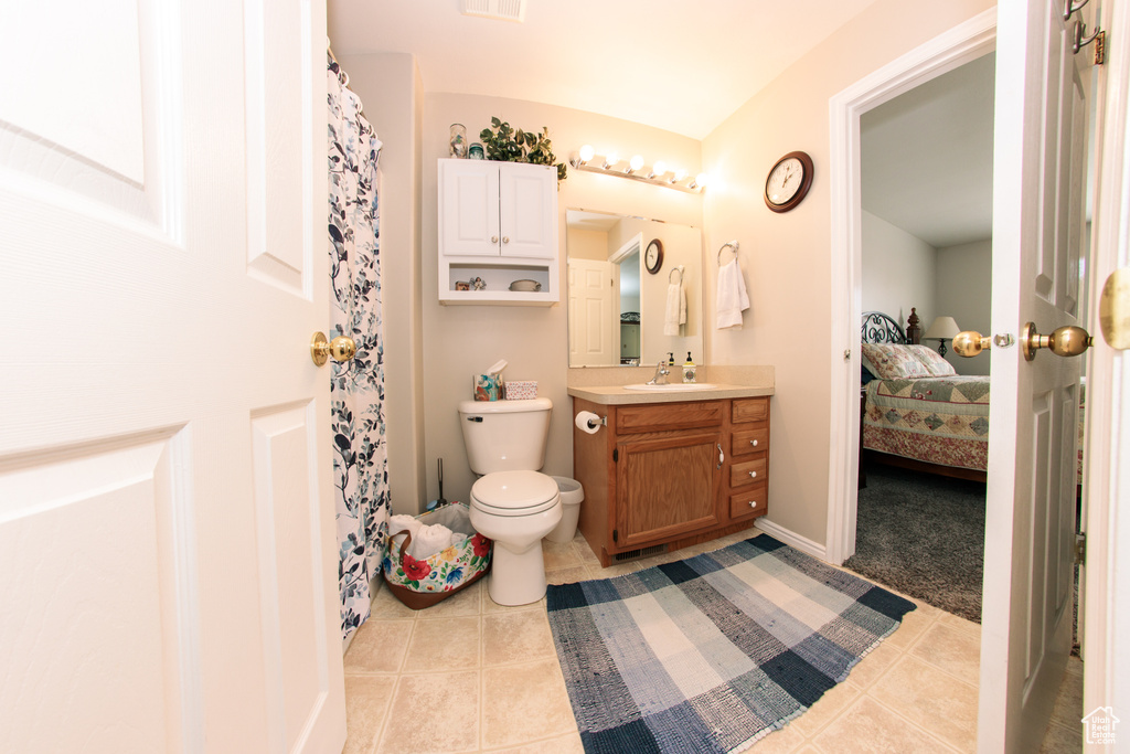 Bathroom featuring tile patterned floors, vanity, ensuite bath, and toilet