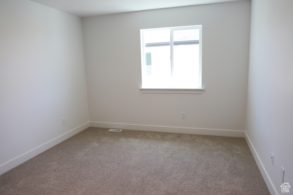 Carpeted spare room with baseboards