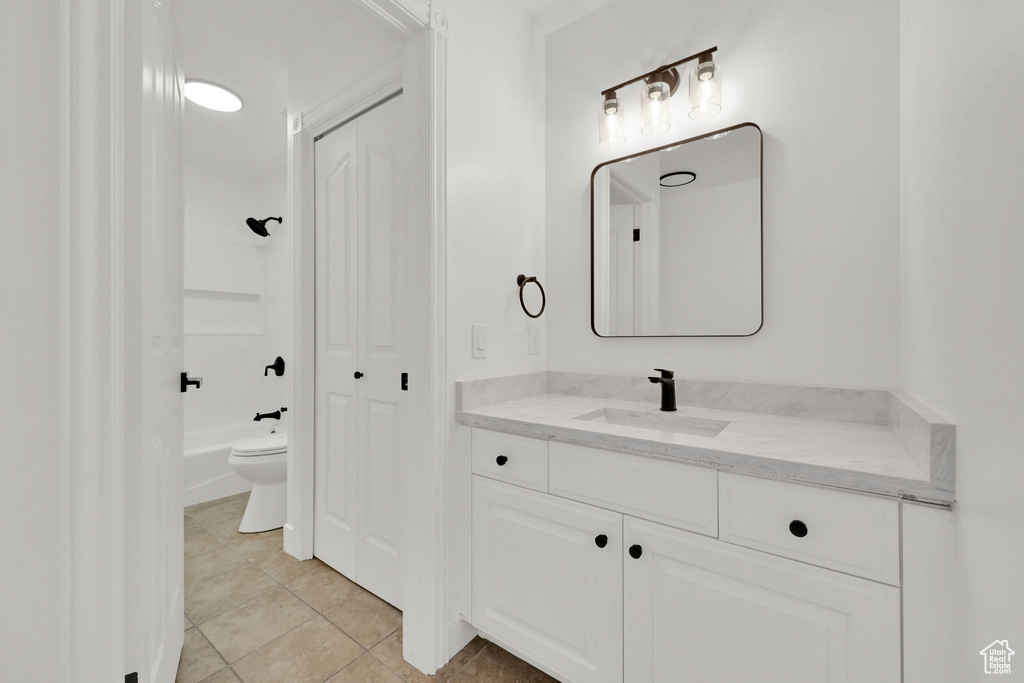 Full bathroom featuring vanity, toilet, a closet, and tile patterned floors