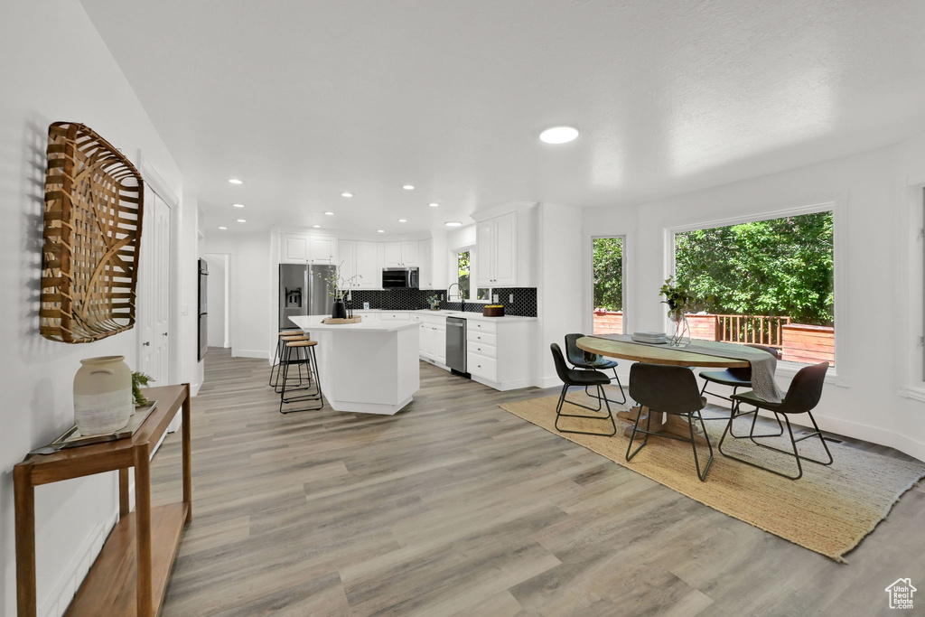 Dining area with plenty of natural light, recessed lighting, and light wood-type flooring