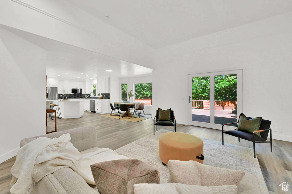 Living room with recessed lighting, light wood finished floors, and baseboards