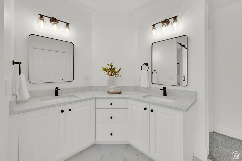 Bathroom featuring double vanity and marble finish floors