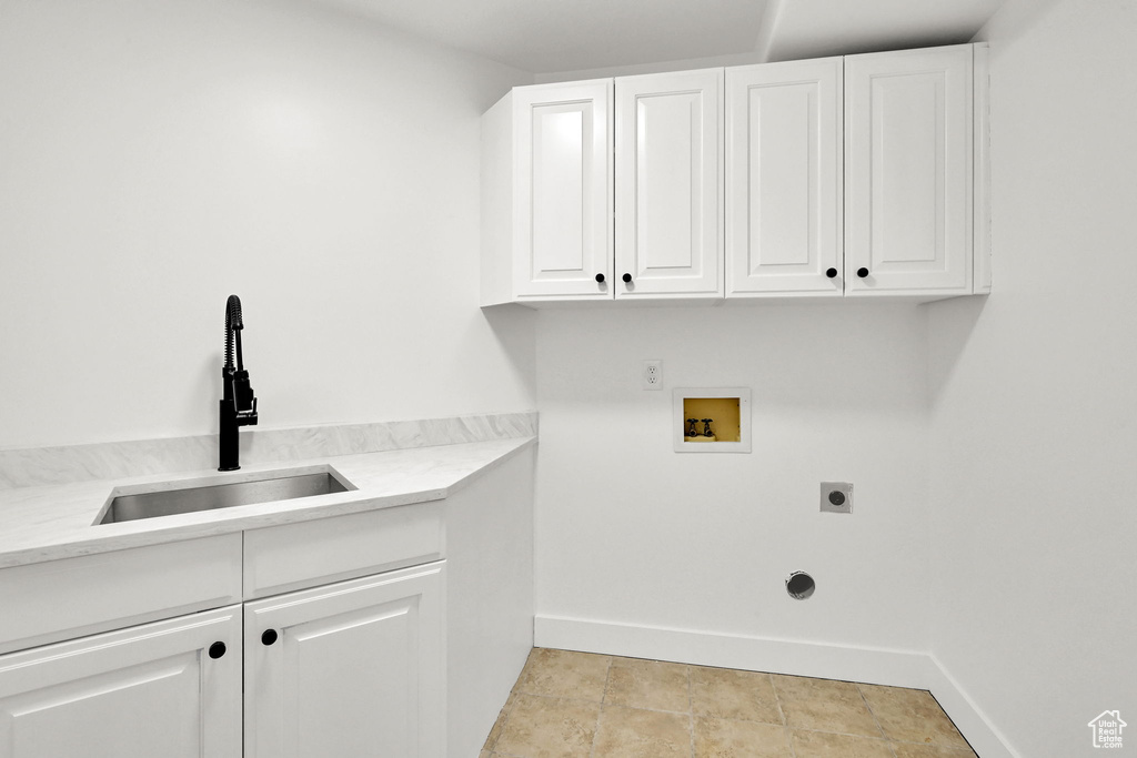 Washroom featuring hookup for a washing machine, hookup for an electric dryer, cabinet space, and baseboards