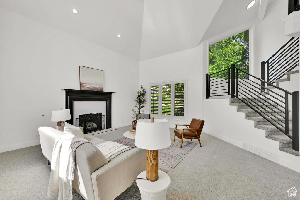 Living area with carpet flooring, stairs, baseboards, a fireplace, and recessed lighting
