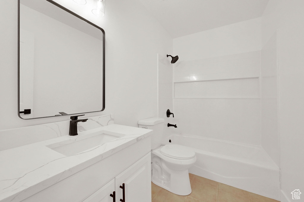 Full bath featuring vanity, toilet,  shower combination, and tile patterned flooring