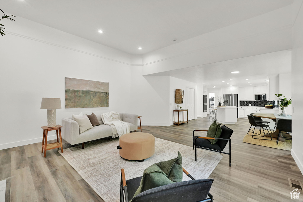 Living area featuring baseboards, light wood finished floors, and recessed lighting