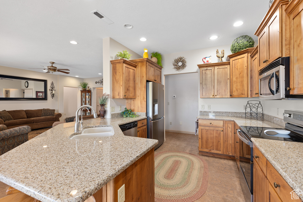 Kitchen with stainless steel appliances, a sink, a peninsula, recessed lighting, and open floor plan