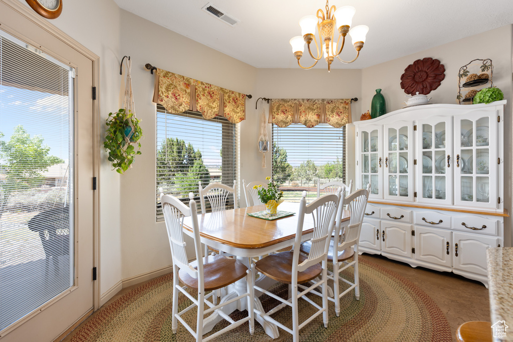 Carpeted dining room with a chandelier