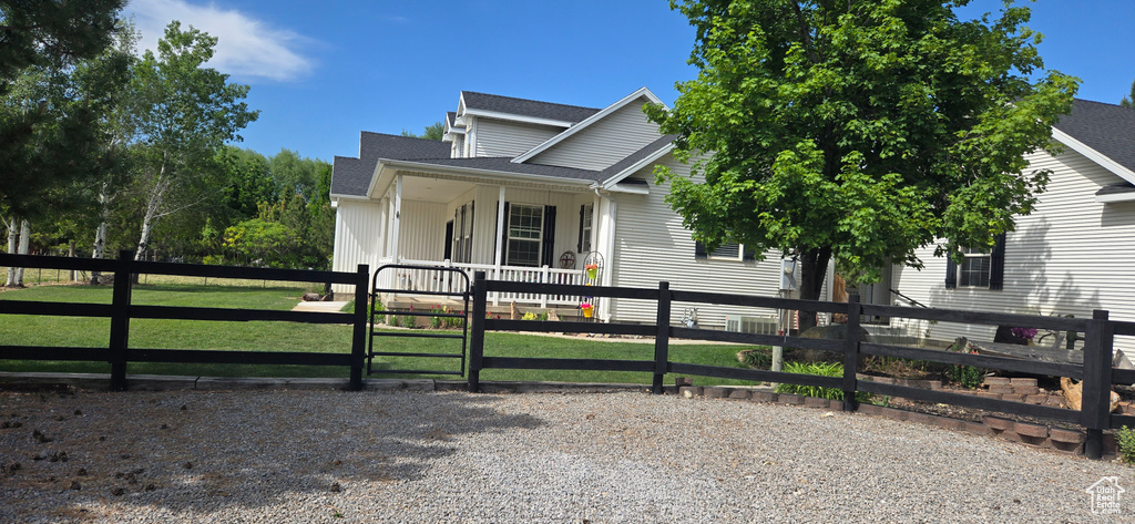 View of front of property with a gate, a porch, and roof with shingles