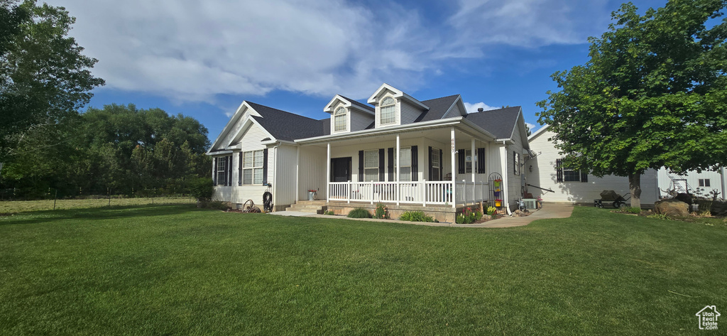 View of front of home with covered porch and a front yard