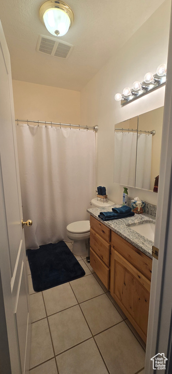 Bathroom featuring vanity, tile patterned floors, toilet, and a shower with shower curtain