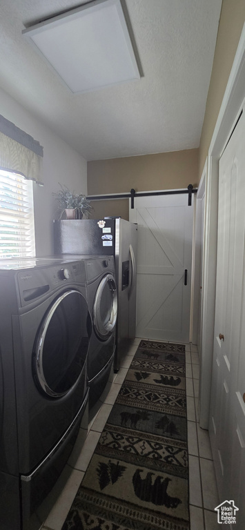 Laundry room featuring light tile patterned flooring and separate washer and dryer
