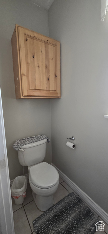 Bathroom featuring tile patterned flooring, toilet, and baseboards