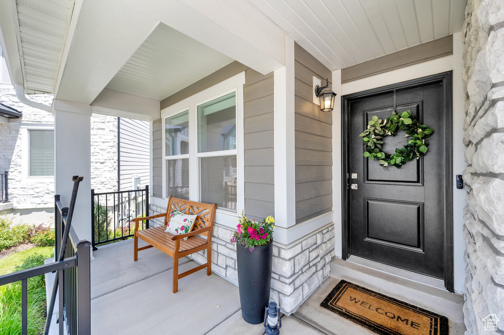 View of exterior entry with a porch and stone siding