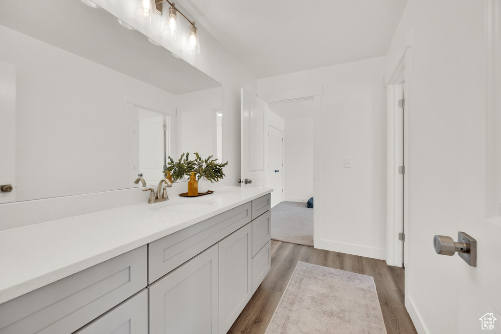 Bathroom with wood finished floors, vanity, and baseboards