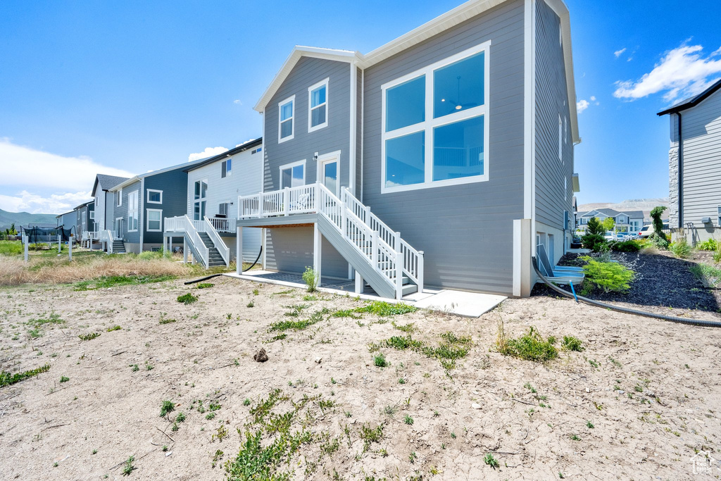 Rear view of property featuring stairway, a deck, and a residential view