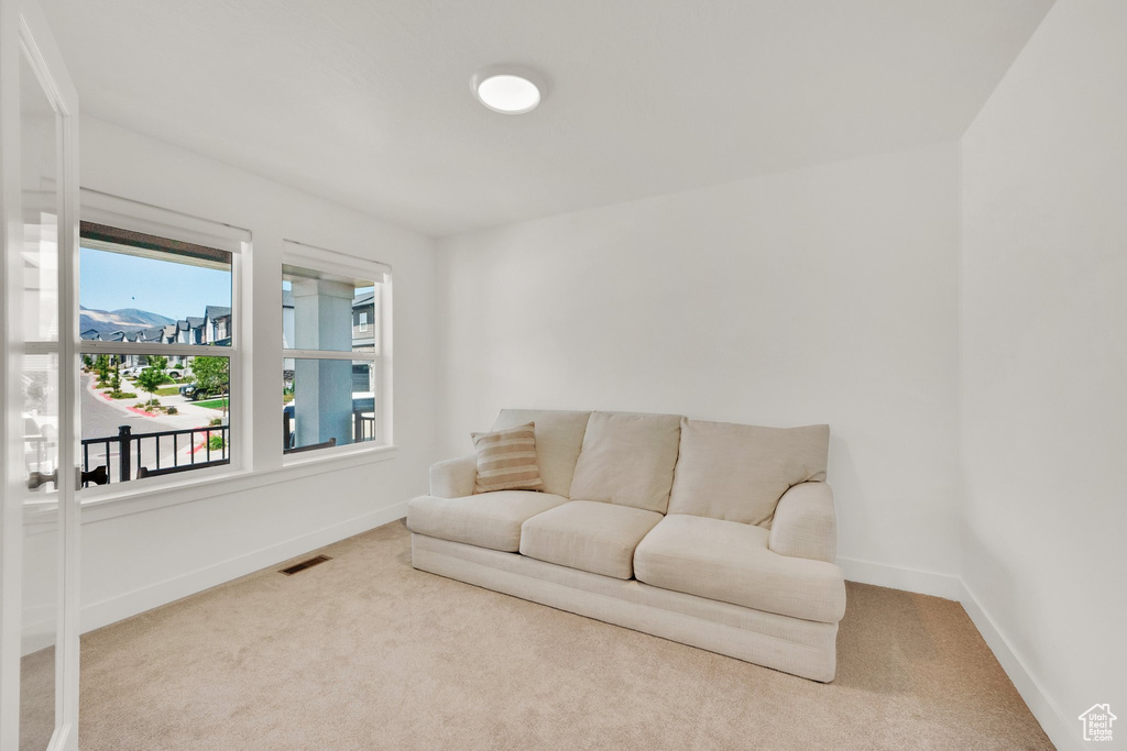 Carpeted living area featuring baseboards