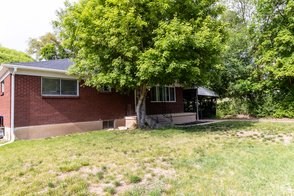 View of front facade featuring a front yard and brick siding