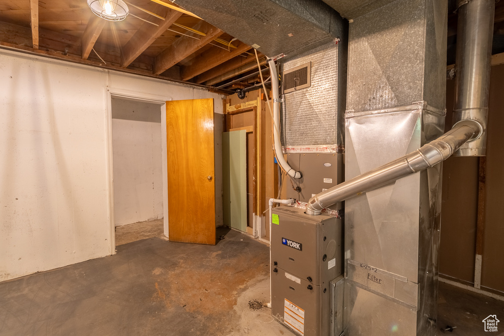 Unfinished basement featuring heating unit