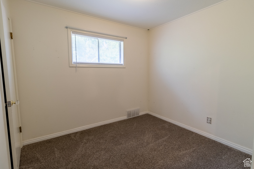 Empty room featuring carpet flooring and baseboards