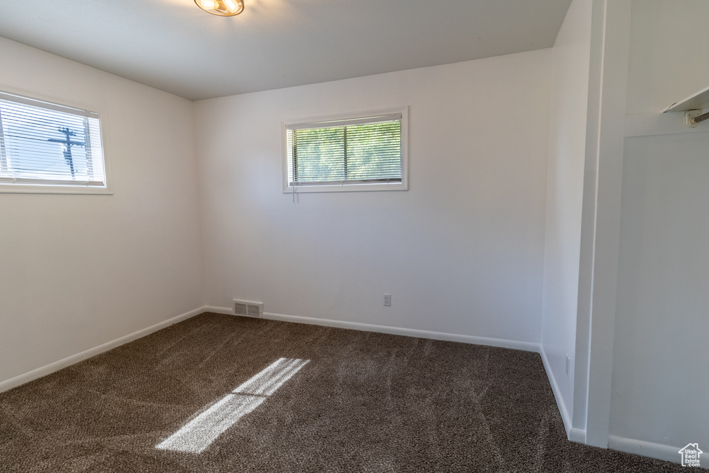 Empty room with carpet flooring and baseboards