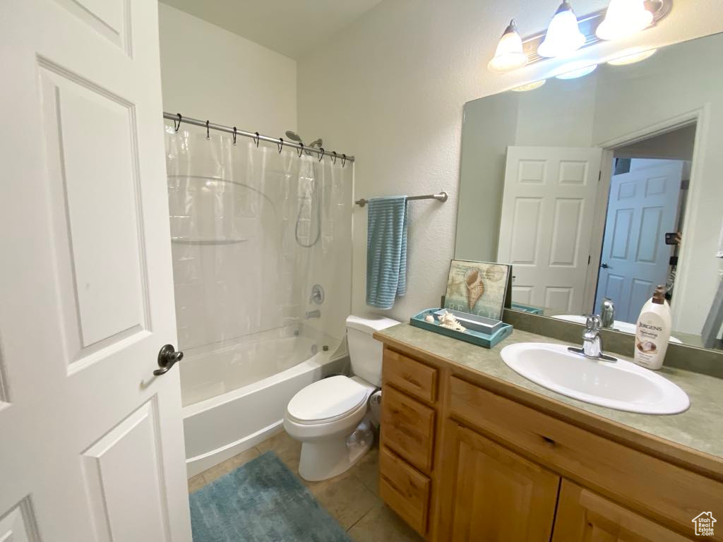Full bath featuring vanity, toilet, tile patterned floors, and shower / bath combo