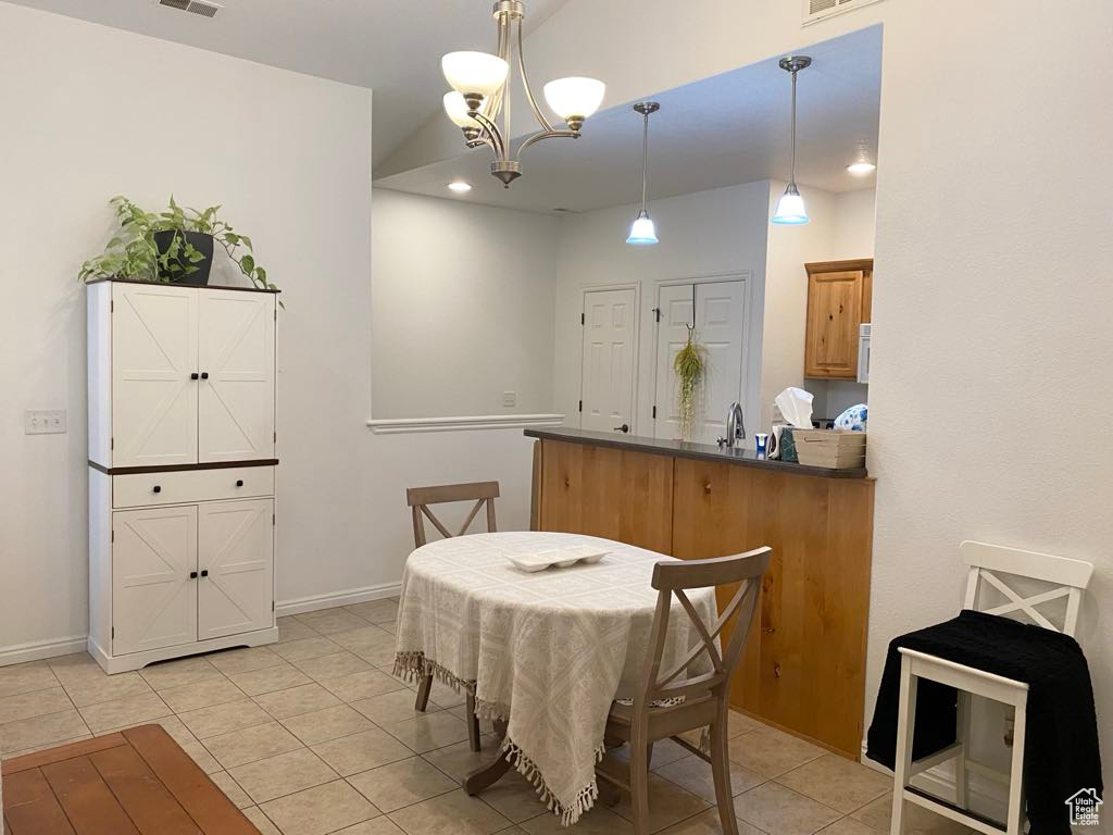 Dining room with light tile patterned floors, a chandelier, baseboards, and recessed lighting