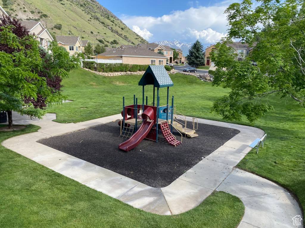 Community jungle gym with a lawn, a residential view, and a mountain view