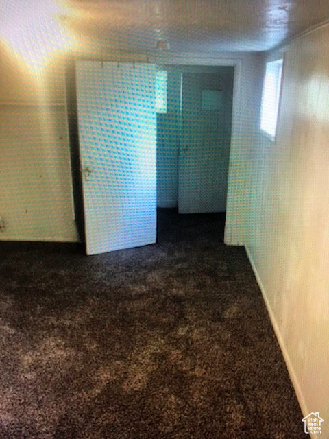 Spare room featuring dark colored carpet