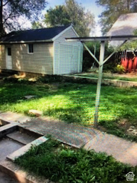 View of grassy yard with an outdoor structure