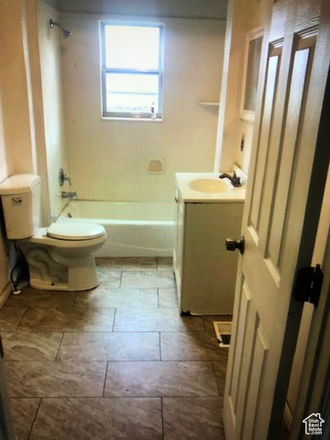 Bathroom featuring vanity, toilet, and bathtub / shower combination