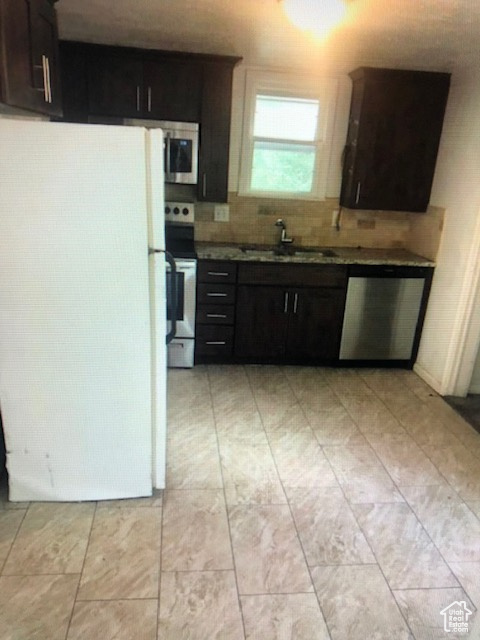 Kitchen with stainless steel appliances, a sink, and tasteful backsplash