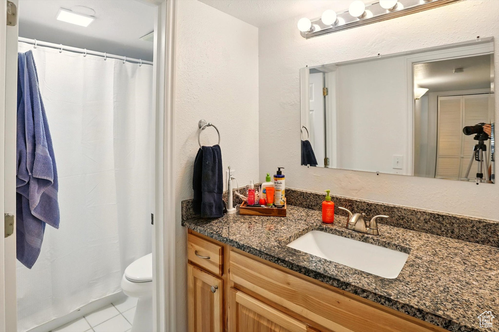 Bathroom with vanity, toilet, tile patterned flooring, a shower with curtain, and a textured wall