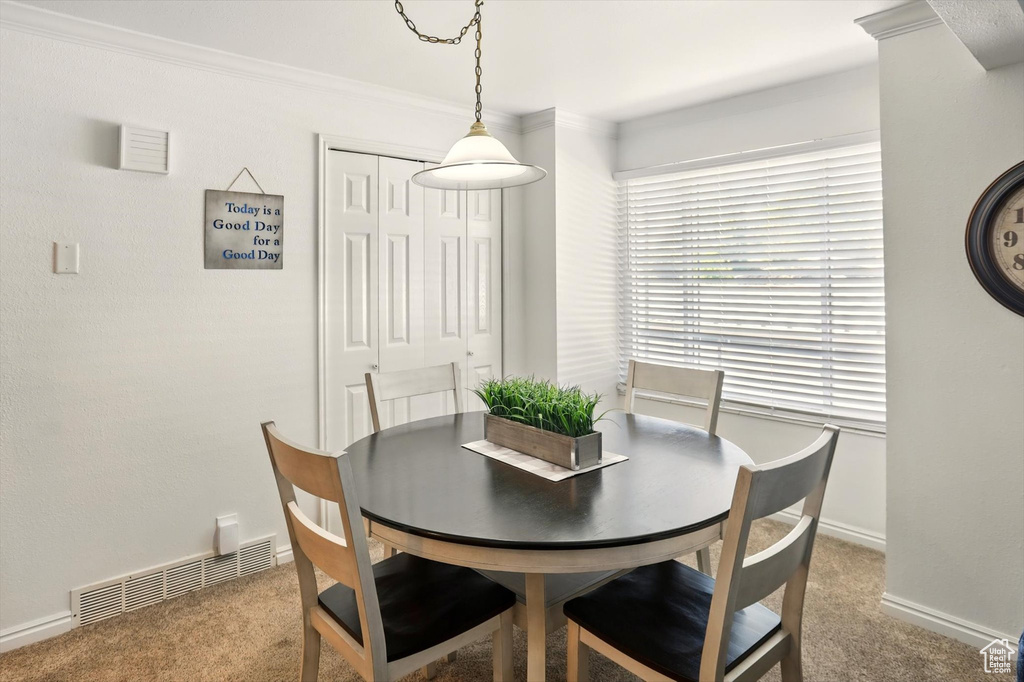 Dining space featuring carpet floors, baseboards, and crown molding
