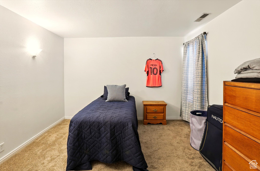 Bedroom featuring light carpet and baseboards