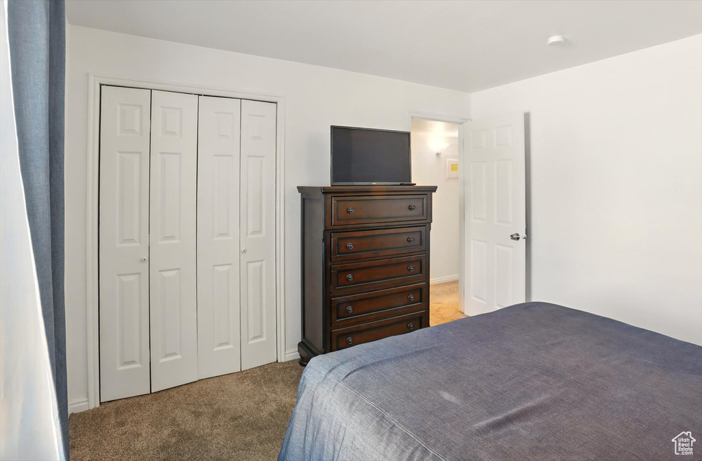 Carpeted bedroom with a closet