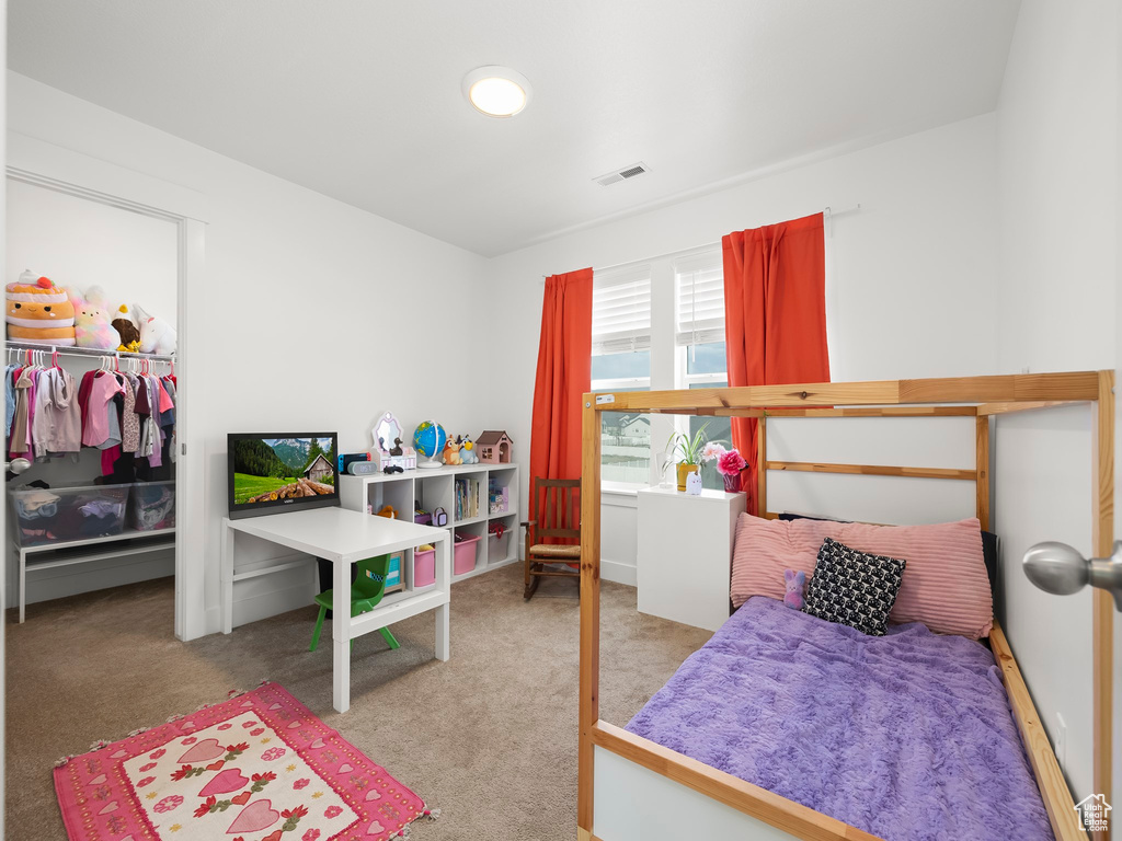 Carpeted bedroom featuring a closet and a walk in closet
