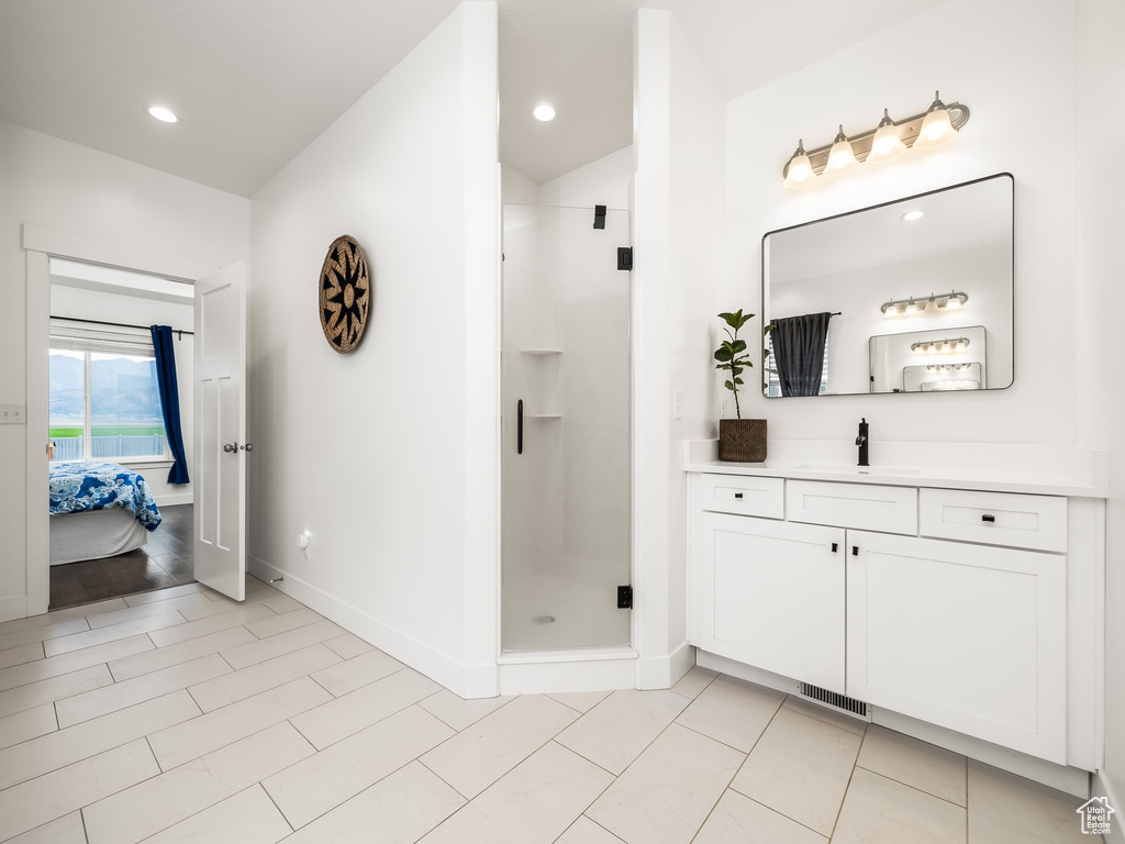 Ensuite bathroom with vanity, a stall shower, baseboards, and recessed lighting