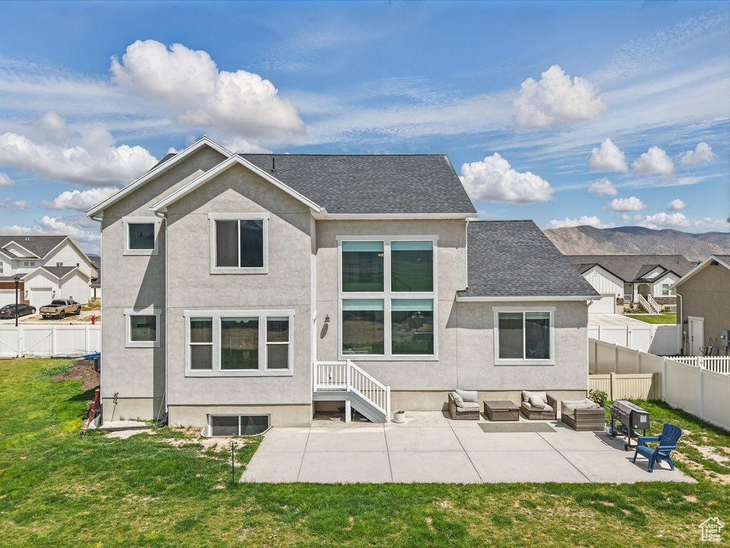 Rear view of house with outdoor lounge area, stucco siding, a patio area, a shingled roof, and a residential view