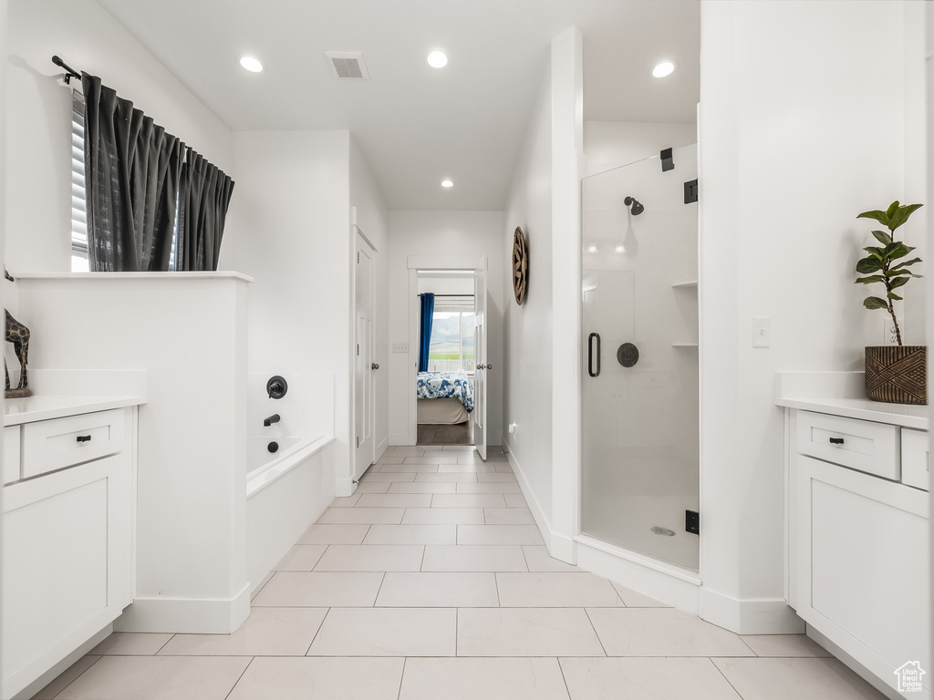 Ensuite bathroom with a shower stall, a garden tub, vanity, baseboards, and recessed lighting