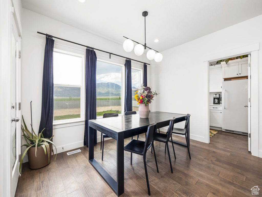 Dining space featuring dark wood finished floors, baseboards, and recessed lighting