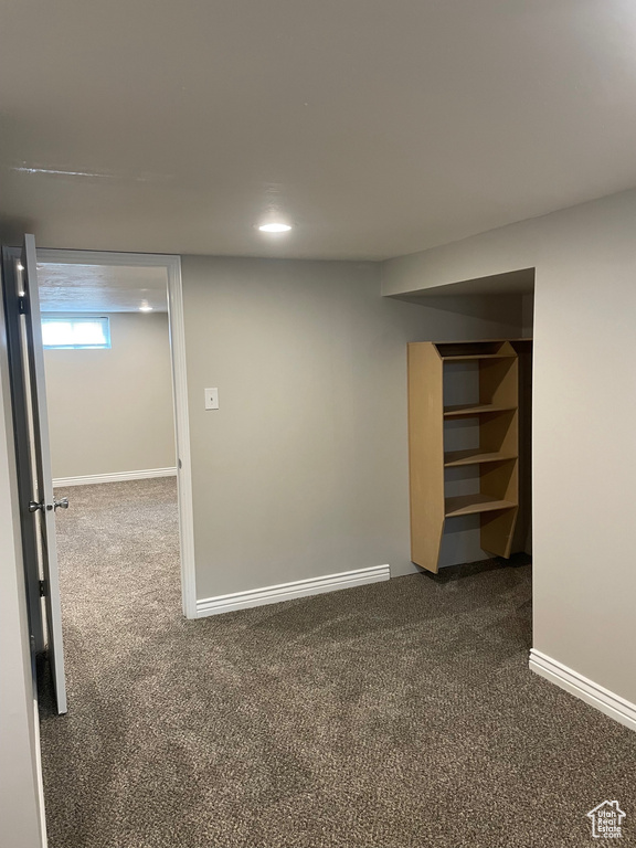 Below grade area featuring dark carpet, baseboards, and recessed lighting