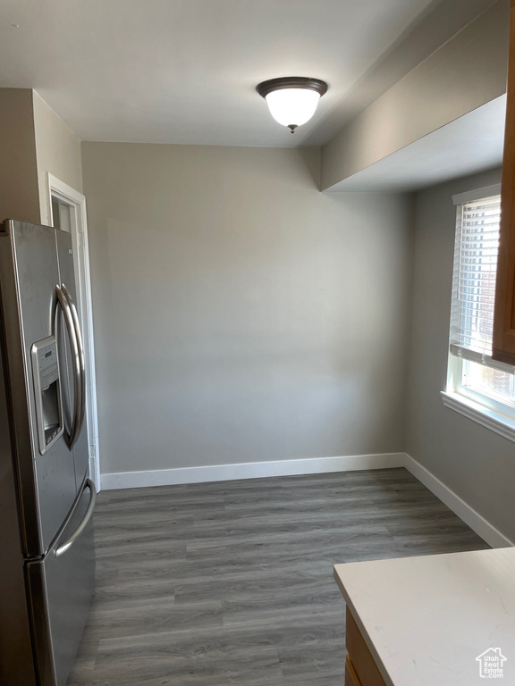 Kitchen featuring stainless steel refrigerator with ice dispenser, dark wood-type flooring, baseboards, and light countertops