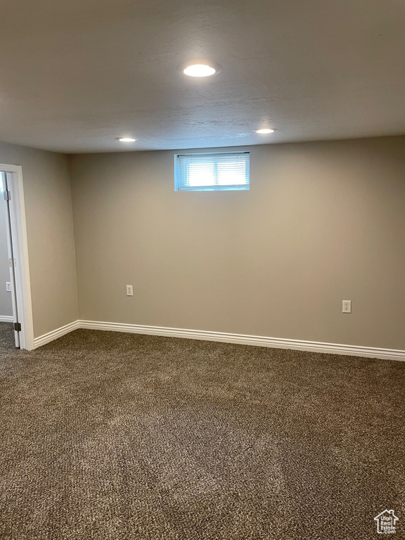 Below grade area featuring dark colored carpet, recessed lighting, and baseboards