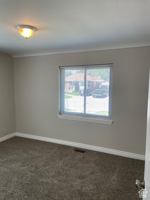 Empty room featuring carpet and baseboards