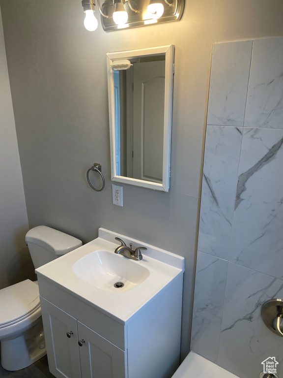 Full bath featuring vanity, toilet, and a shower