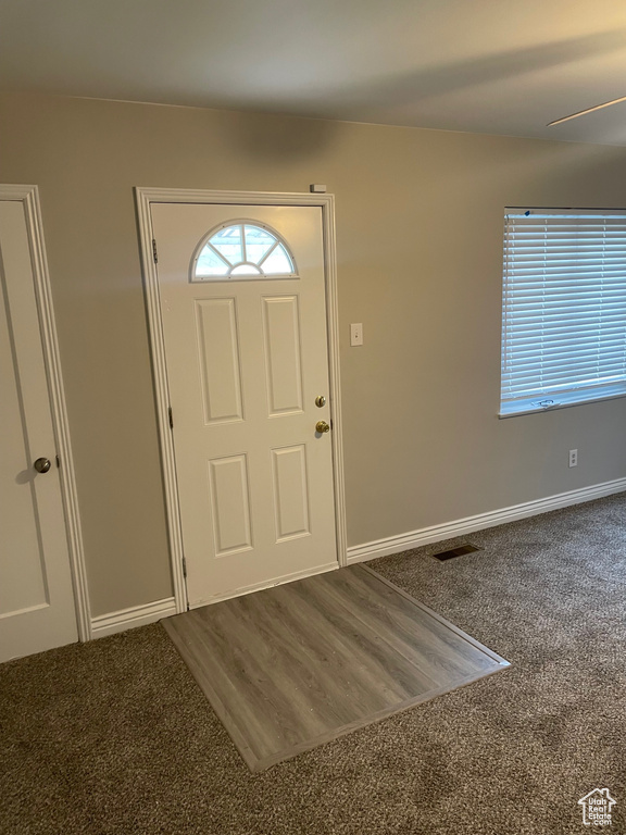 Foyer featuring carpet flooring and baseboards
