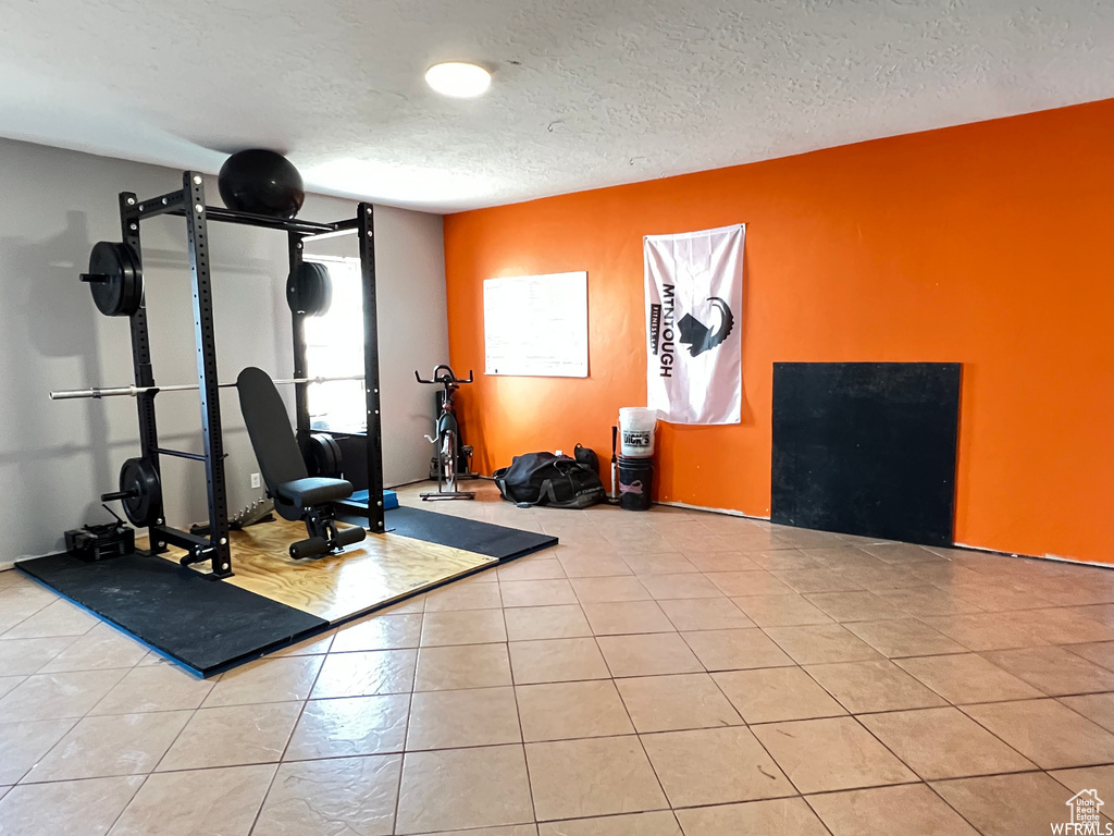 Exercise room with a textured ceiling and tile patterned floors