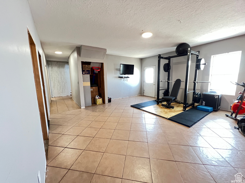 Workout room featuring light tile patterned floors and a textured ceiling